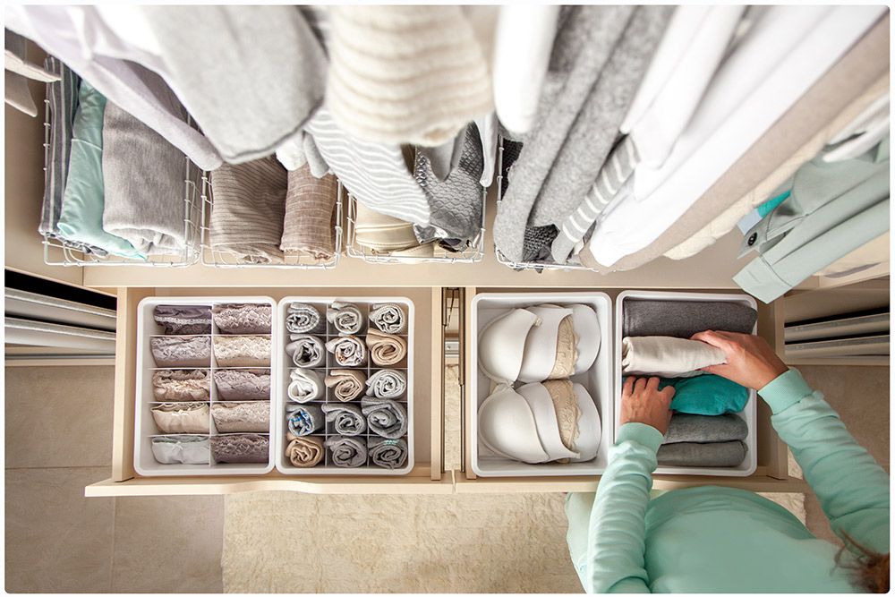 You can see the inside of a closet seen from above, where all the clothes are organized by sets in small boxes inside the drawers. This way the closet looks tidy and it’s easier to find things.